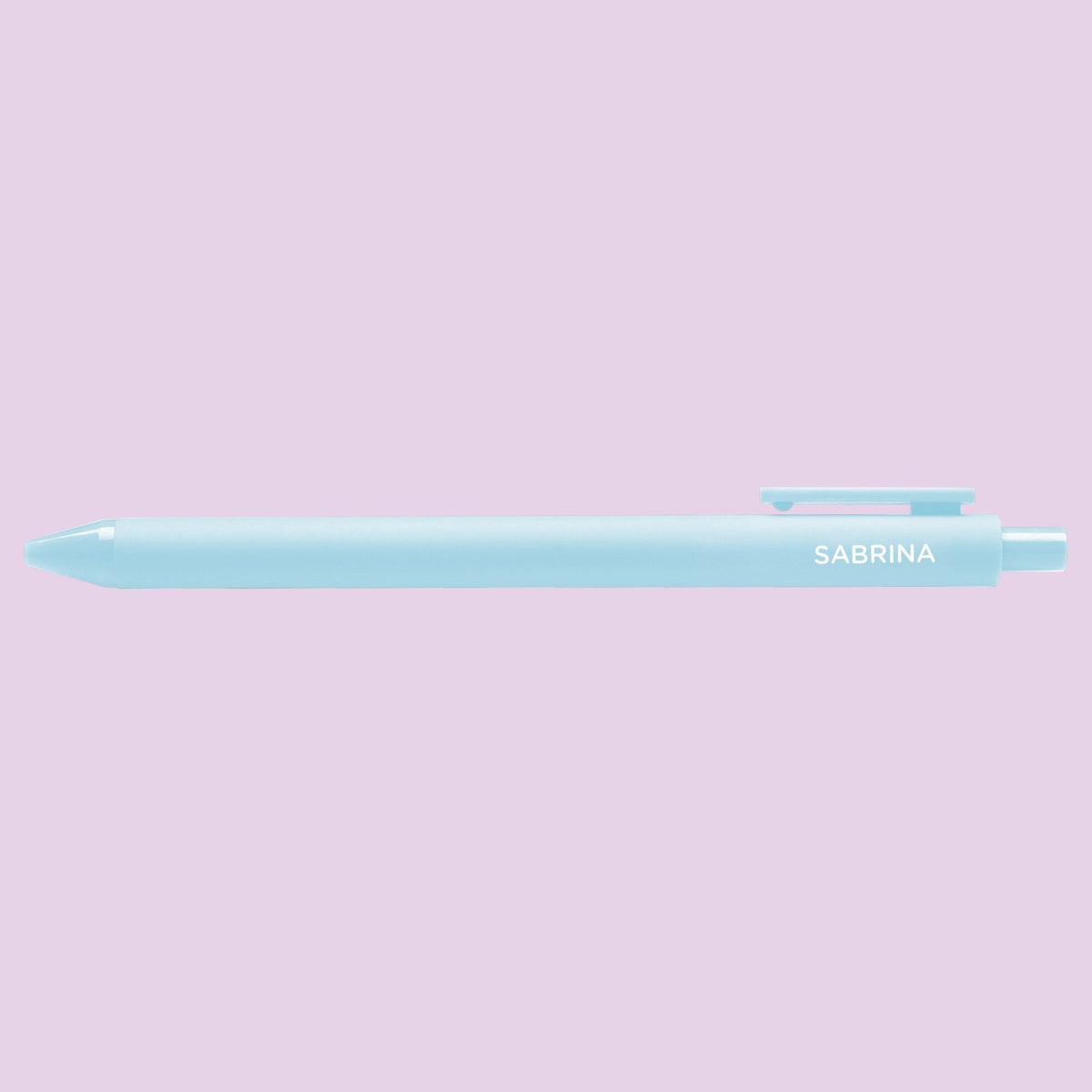 Sabrina pen flat lay — powder blue pop culture gel pen on a light purple background by indie artist MangoIllustrated