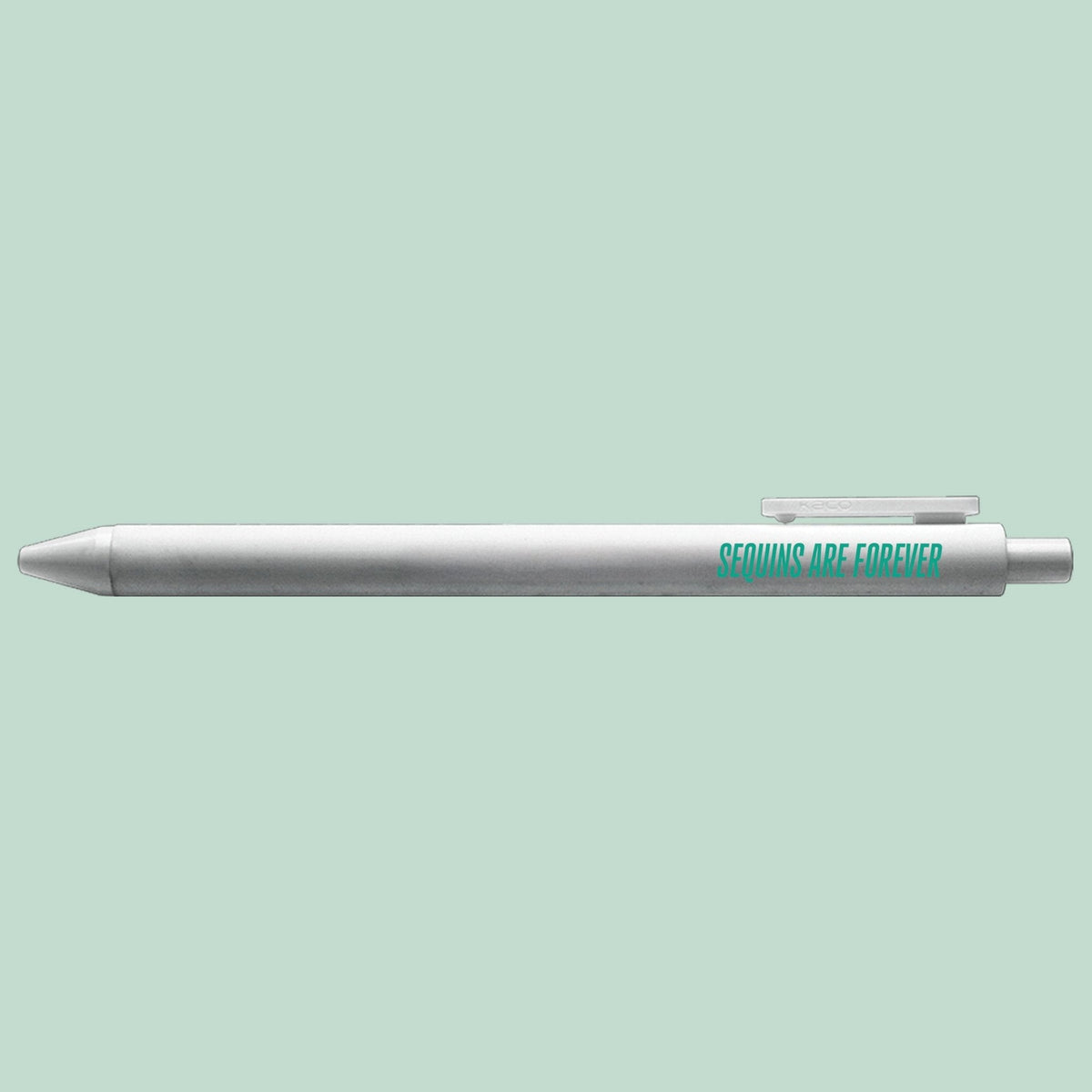 Sequins Are Forever pen flat lay — silver gel pen with teal text for desk gifts by indie artist MangoIllustrated