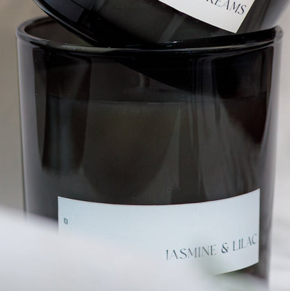 Two black candles with labels on a light background
