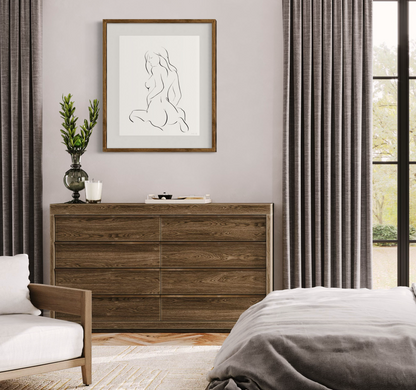 Black and white elegant illustration of sensual woman in seated pose with feminine curves; matted and framed on wall in neutral modern bedroom