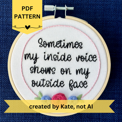 PDF pattern created by Kate, not AI. Completed embroidery hoop reads, "Sometimes my inside voice shows on my outside face". Quote in handwriting font and hand embroidered in black. Words are centered in a floral frame, which is light pink and embellished with cheerful fuchsia and periwinkle roses and light green leaves sewn with embroidery thread. Fabric is white cotton. Framed in light wood embroidery hoop and displayed as wall art or Christmas ornament.