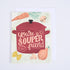 A folded greeting card with a red pot and vegetables on the front, with the text &