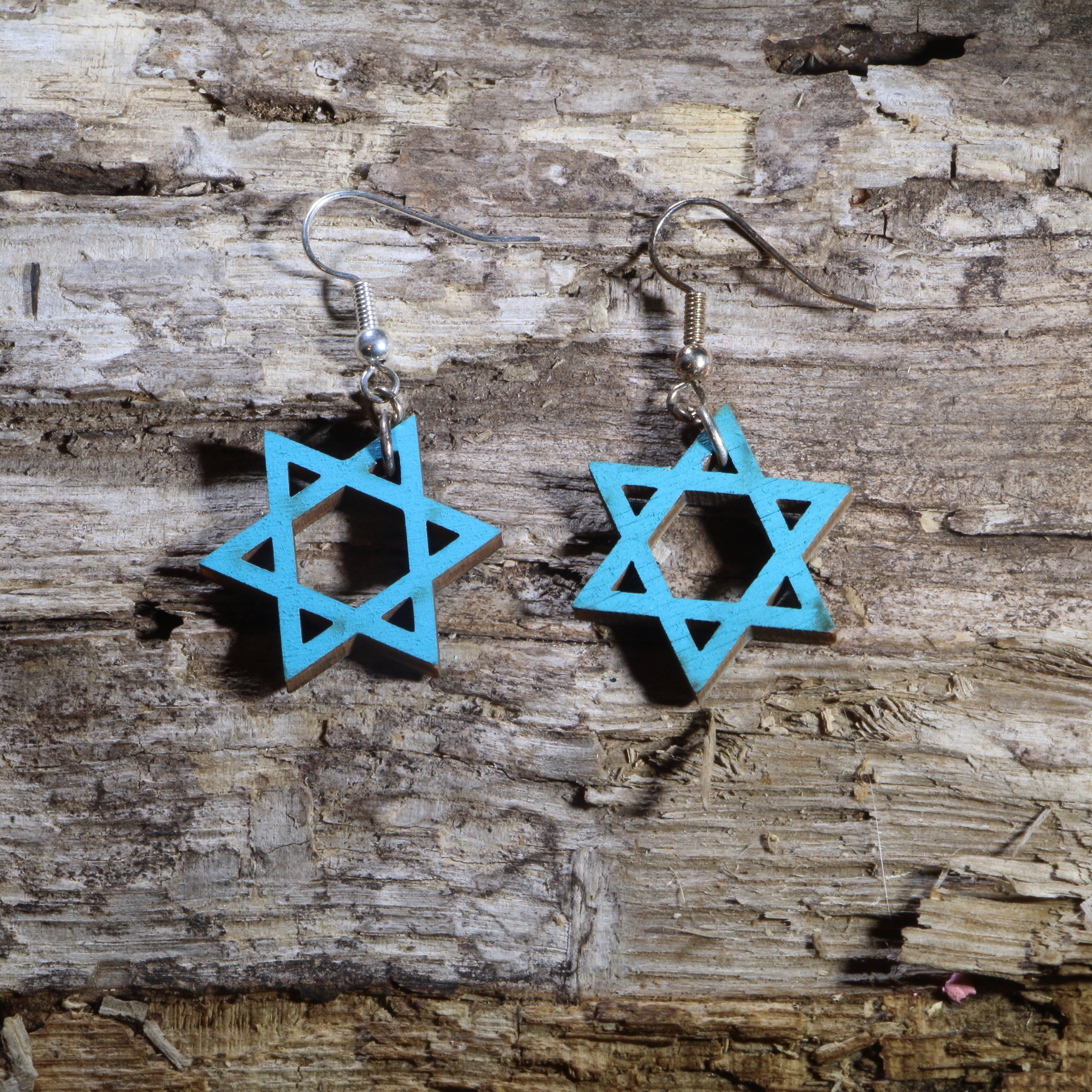 Hand-painted wooden Star of David dangle earrings featuring the iconic six-pointed Jewish symbol in a vibrant blue design. Crafted from lightweight wood with hypoallergenic .925 sterling silver hooks, these meaningful earrings are perfect for Jewish heritage, Hanukkah celebrations, synagogue events, faith-inspired fashion, cultural festivals, Bat Mitzvah gifts, and anyone who appreciates beautiful Judaica jewelry.