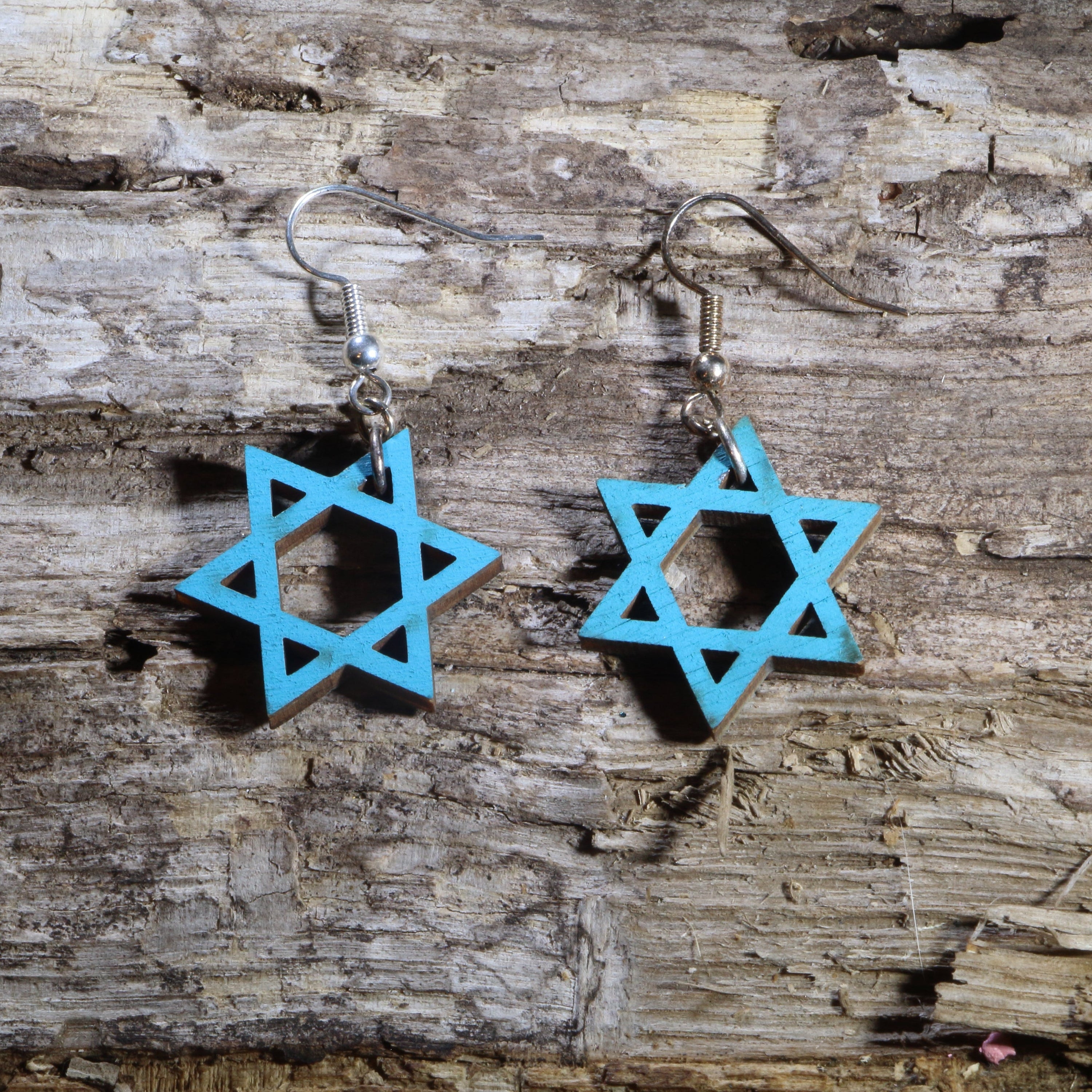 Hand-painted wooden Star of David dangle earrings featuring the iconic six-pointed Jewish symbol in a vibrant blue design. Crafted from lightweight wood with hypoallergenic .925 sterling silver hooks, these meaningful earrings are perfect for Jewish heritage, Hanukkah celebrations, synagogue events, faith-inspired fashion, cultural festivals, Bat Mitzvah gifts, and anyone who appreciates beautiful Judaica jewelry.