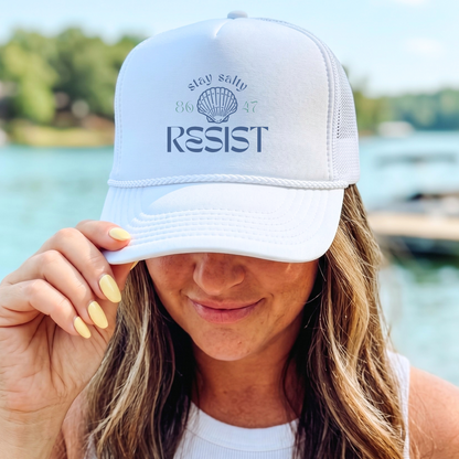 A woman wearing a white trucker hat with &