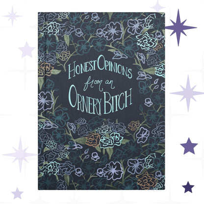 Sweary dark floral hardcover journal with hand-lettered text reading Honest Opinions from an Ornery Bitch surrounded by gothic botanical pattern in lavender teal and copper on navy ground