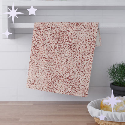 Terracotta red terrazzo tea towel folded and draped over white shaker shelf rail in kitchen setting with pine plant and bread basket