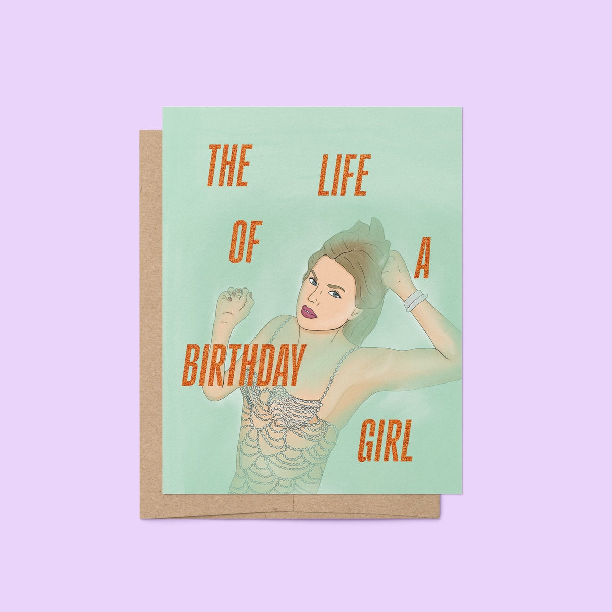 The Life of a Birthday Girl card flat lay — illustrated showgirl birthday card on a soft purple background by indie artist MangoIllustrated