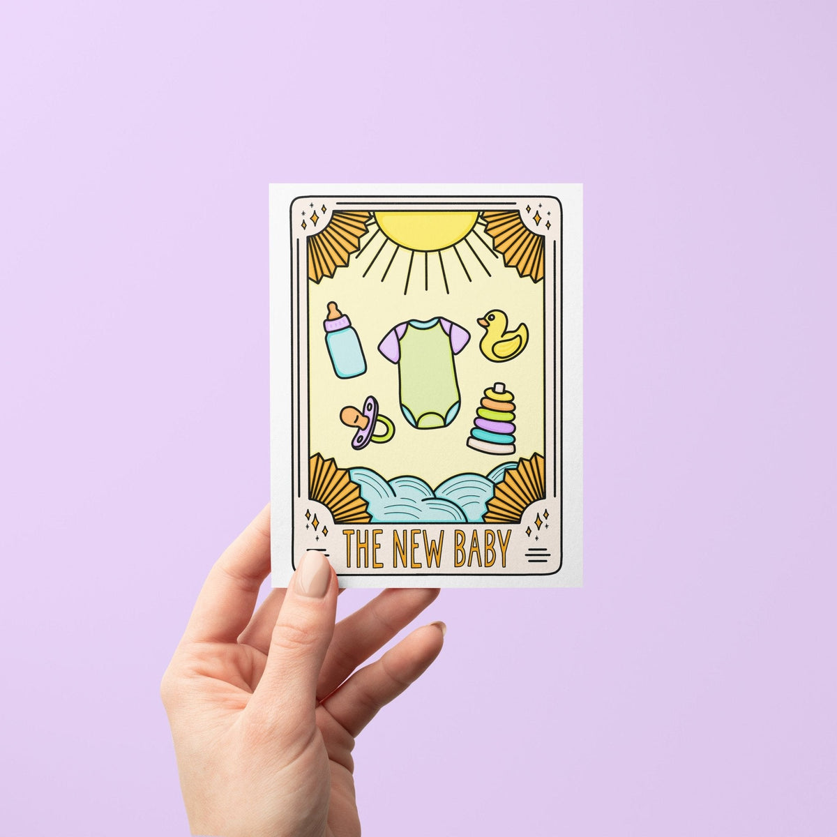 The New Baby Tarot Card Congratulations Card detail — close up of the bottle, pacifier and stacking ring illustrations by indie artist MangoIllustrated