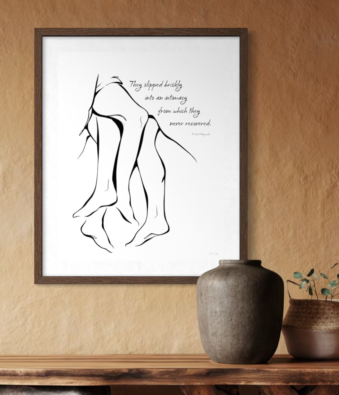 Wood framed print of "Together," intimate entwined romantic couple with a quote from Fitzgerald, hung on a natural textured wall above rustic decor