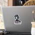 Small chibi vampire girl sticker with plum eyes and THIRSTY lettering on the back of a silver laptop