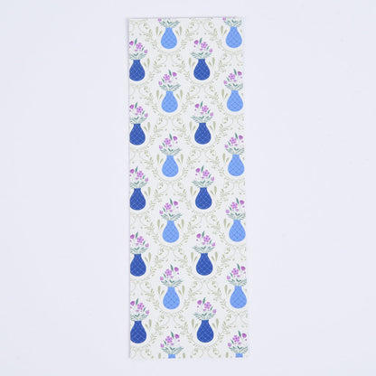 A bookmark with a floral pattern featuring blue flower vases on a light sage green background