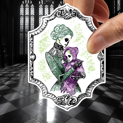 Victorian skeleton mother and baby sticker held between fingers above a black and white checkered stone floor