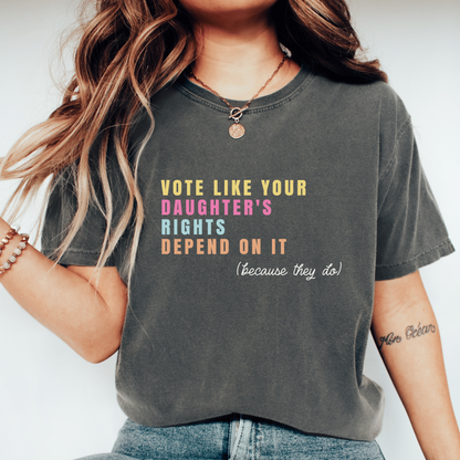 A woman wearing a dark gray graphic t-shirt with the text &