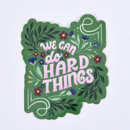 floral sticker with lettering "we can do hard things" on a green background