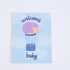 A greeting card with a blue background featuring an illustration of a hedgehog in a hot air balloon, with the text &