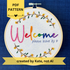 PDF pattern created by Kate, not AI. "Welcome, please leave by 9". Welcome hand embroidered in rainbow colors from pink to purple. Please leave by 9 hand embroidered in a light blue gray. A floral wreath of flower stems with yellow and orange buds create the impression of a circle. Fabric is white-on-white cotton. Framed in a light wooden embroidery hoop and displayed as wall art.