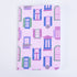 A pocket notebook with a pink background featuring a pattern of windows, flower boxes, and a cat.