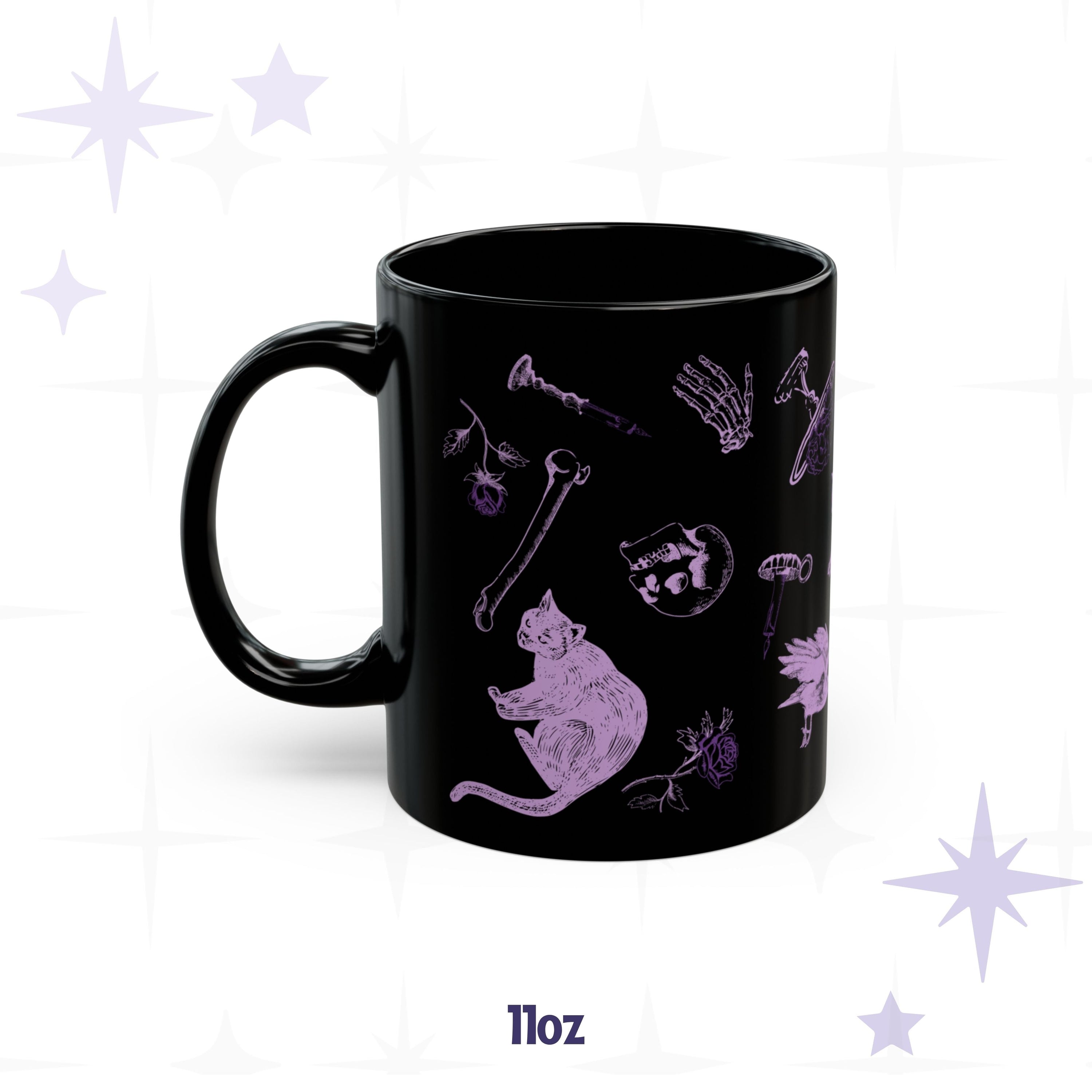 11 oz purple goth mug with a seated black cat, a skull, loose bones, and a rose on glossy black ceramic