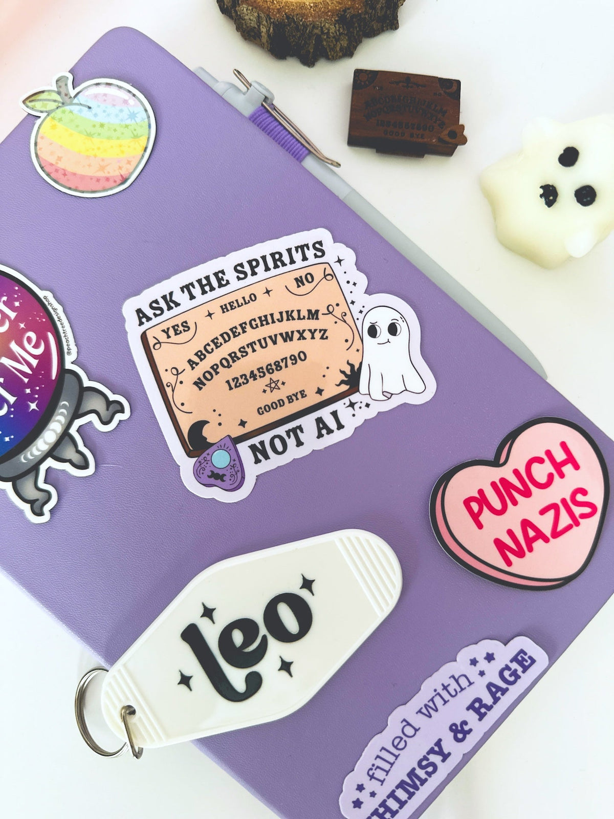 A purple notebook or journal decorated with various whimsical and spooky stickers, including a &