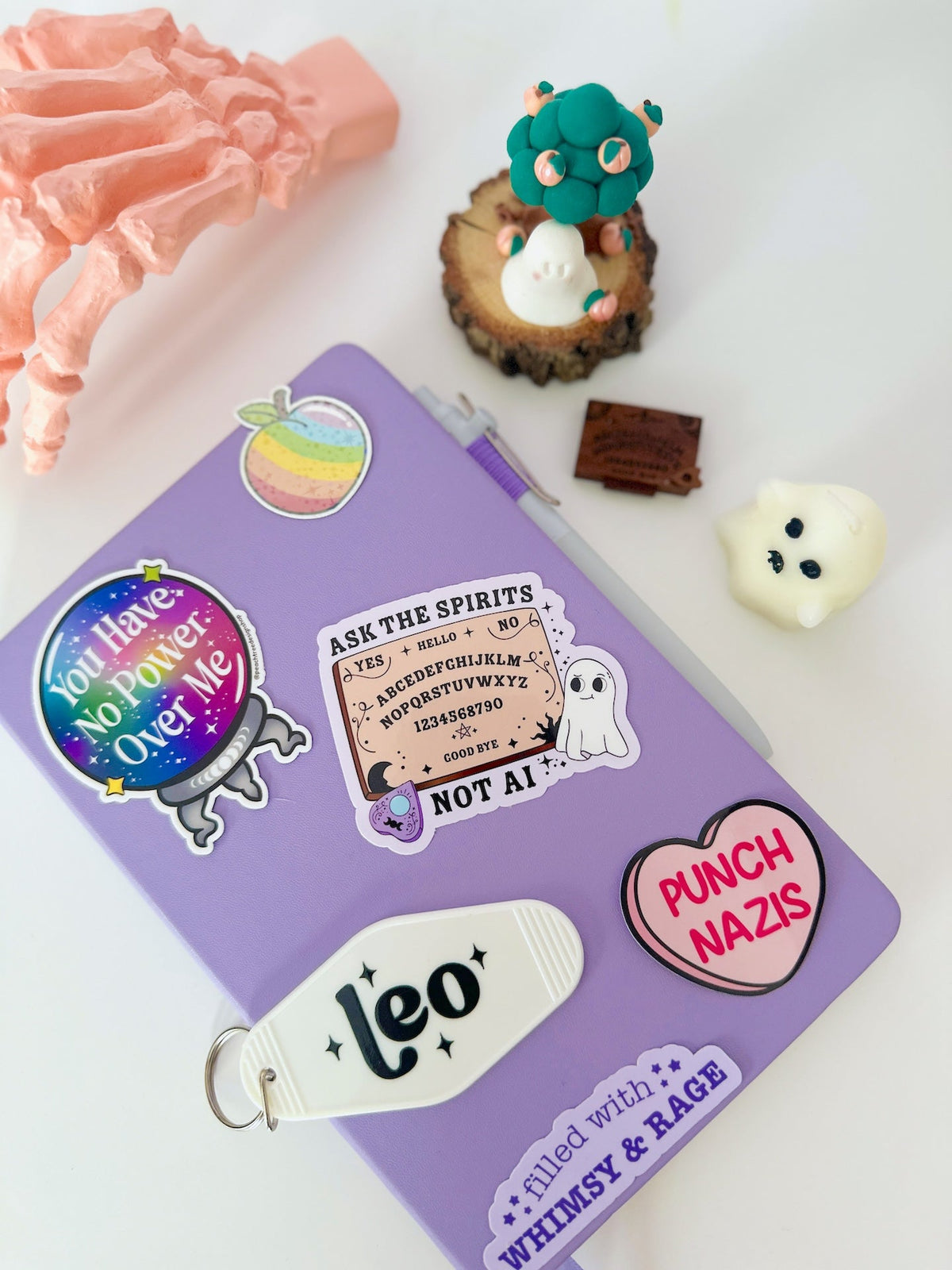 A purple notebook or journal decorated with various whimsical and spooky stickers, including a &