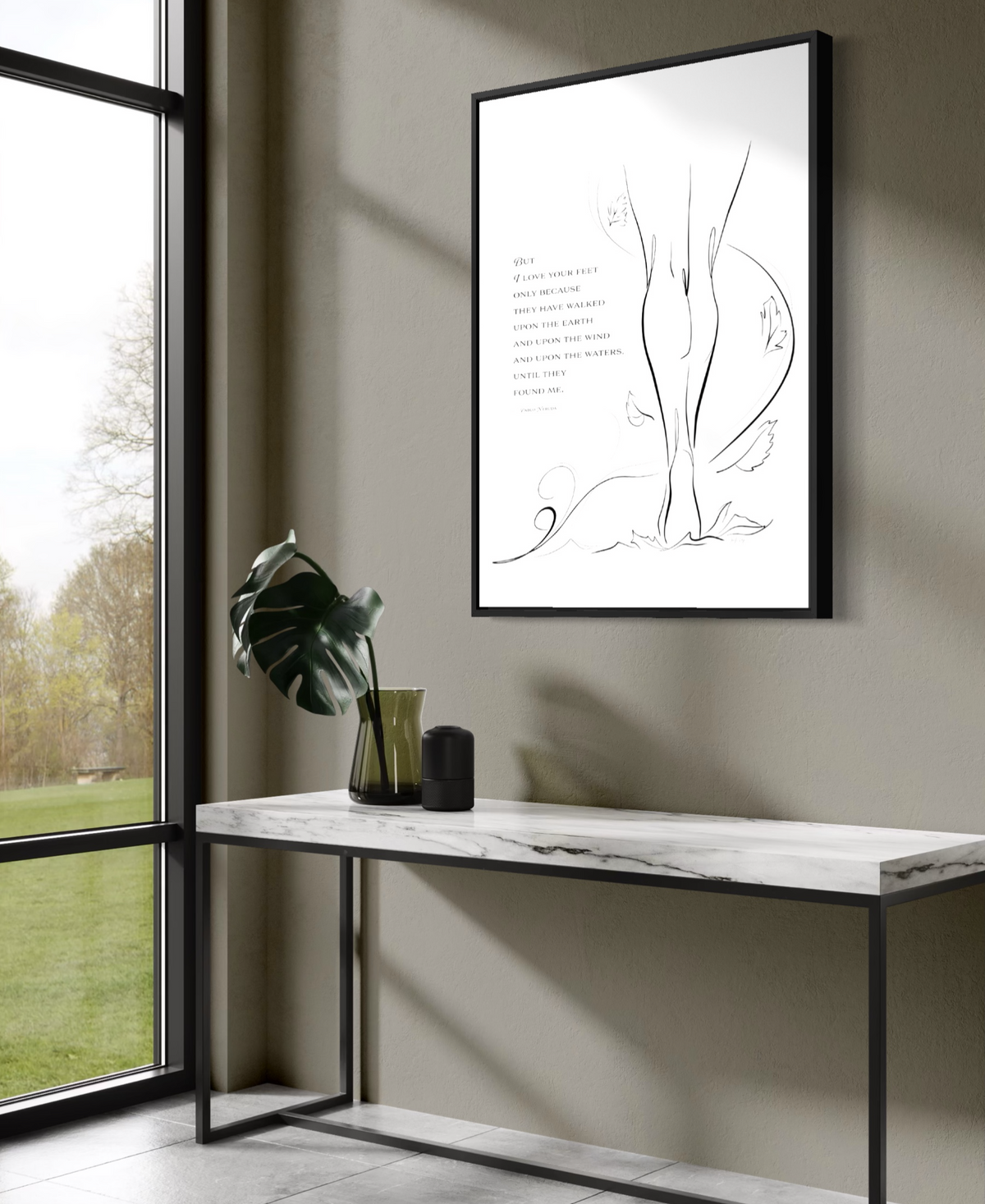 Large framed print of "Walk the Earth" on Aquarelle Rag paper hung on a gray wall above a table, facing a large window