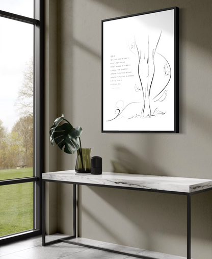 Large framed print of "Walk the Earth" on Aquarelle Rag paper hung on a gray wall above a table, facing a large window