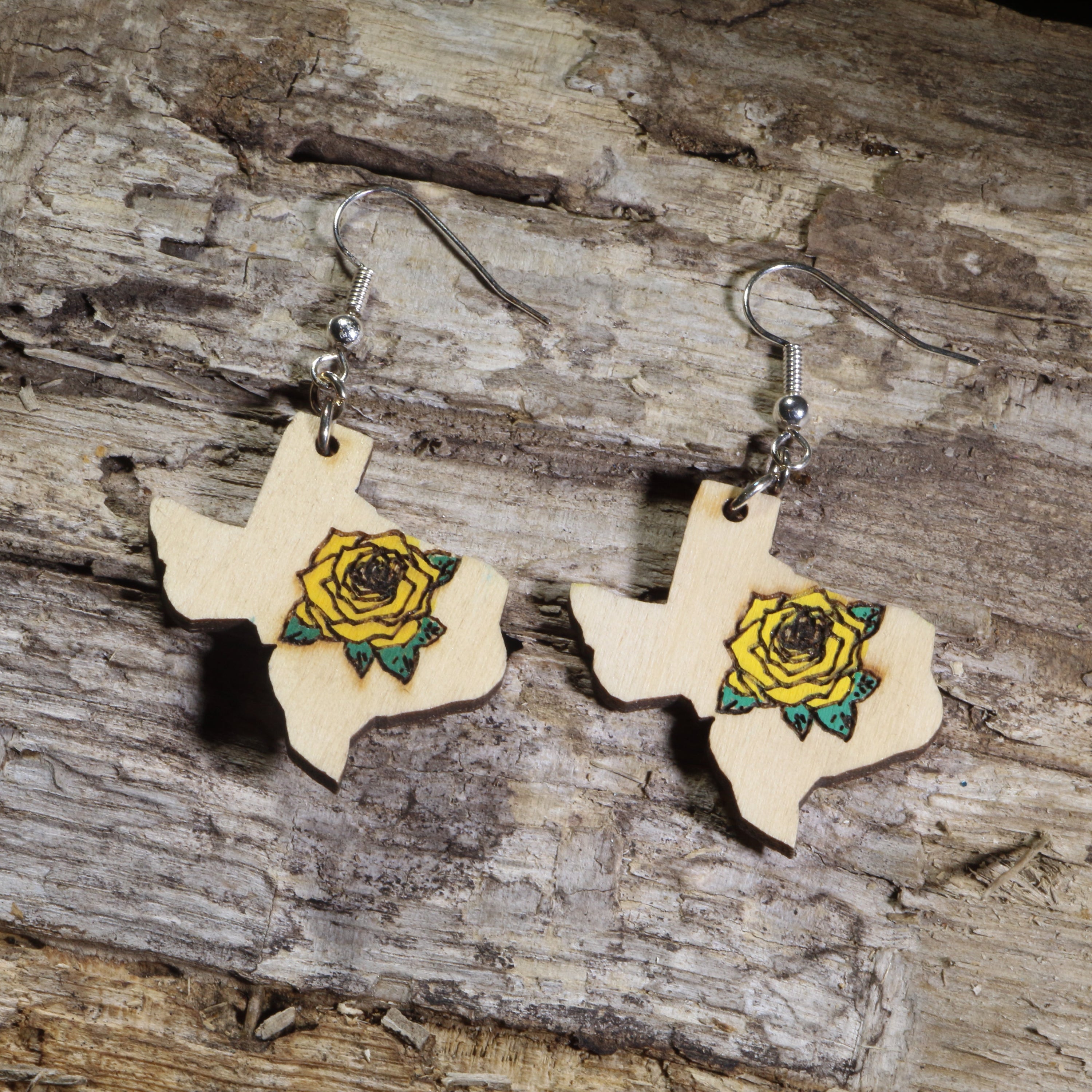 Hand-painted Texas state wooden dangle earrings featuring a yellow rose on hypoallergenic .925 sterling silver hooks. Lightweight Texas flower jewelry perfect for Texas pride, wildflower lovers, gardeners, and fans of the Yellow Rose of Texas.