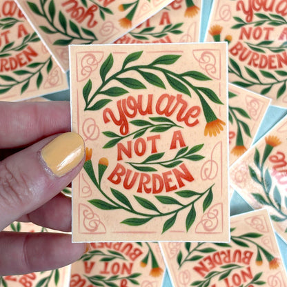 hand holding A sticker with a floral pattern and the text &