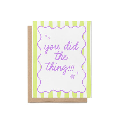 Pastel green striped congratulations card with the phrase "you did the thing!!!" in hand-lettered lavender script, framed by a wavy purple border with playful star and sparkle doodles, paired with a kraft envelope – perfect for graduations, promotions, and everyday wins.