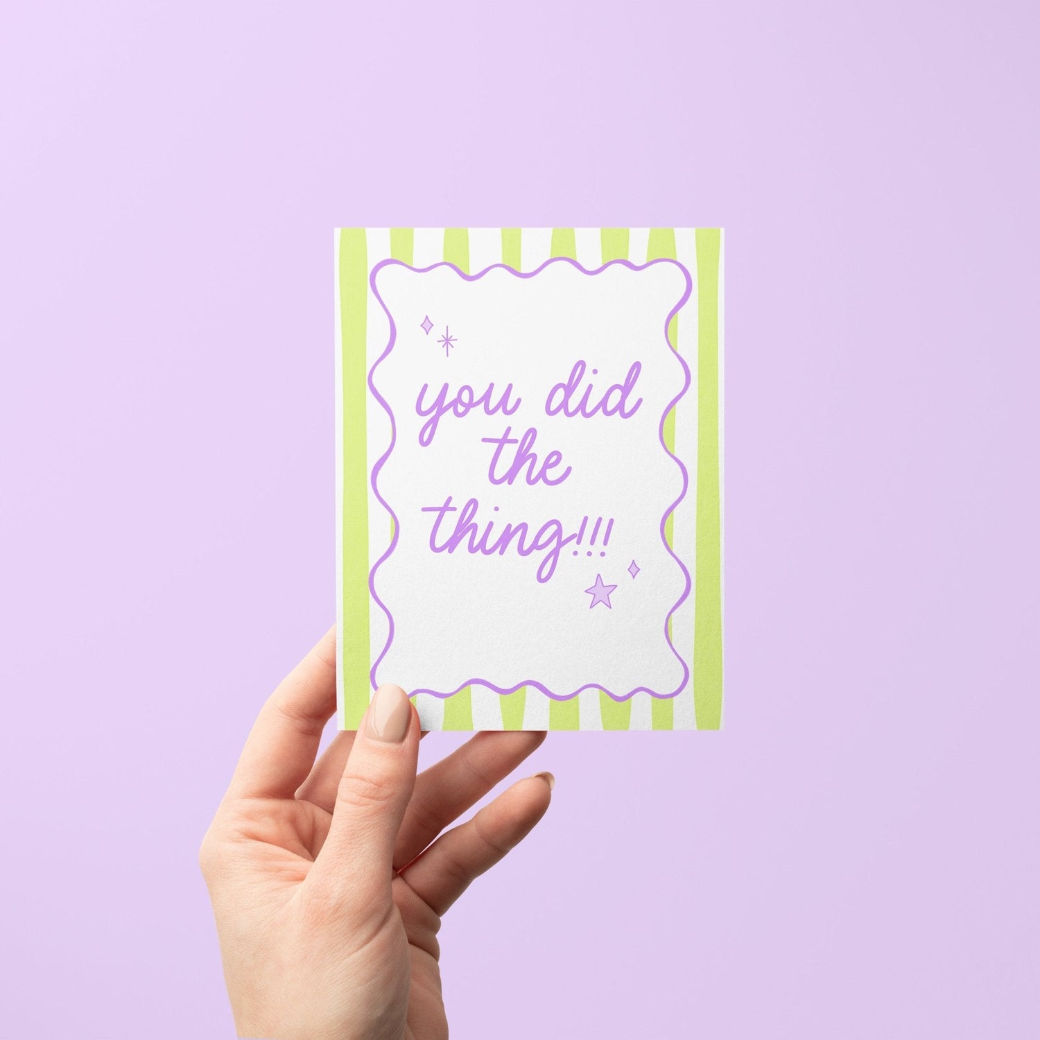 Pastel green striped congratulations card with the phrase "you did the thing!!!" in hand-lettered lavender script, framed by a wavy purple border with playful star and sparkle doodles, paired with a kraft envelope – perfect for graduations, promotions, and everyday wins.