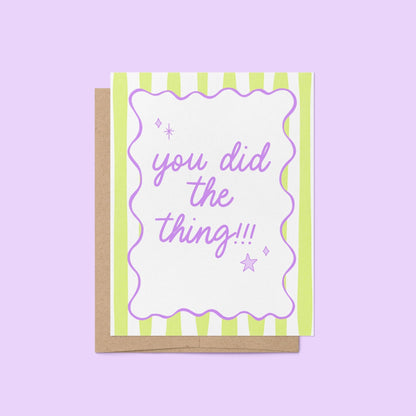 Pastel green striped congratulations card with the phrase "you did the thing!!!" in hand-lettered lavender script, framed by a wavy purple border with playful star and sparkle doodles, paired with a kraft envelope – perfect for graduations, promotions, and everyday wins.